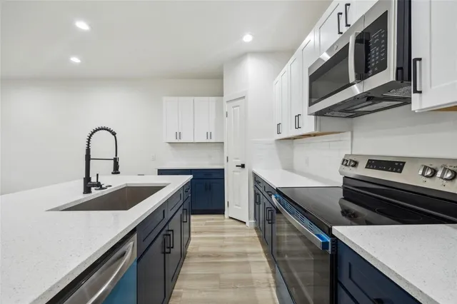 a kitchen with a sink stove and microwave