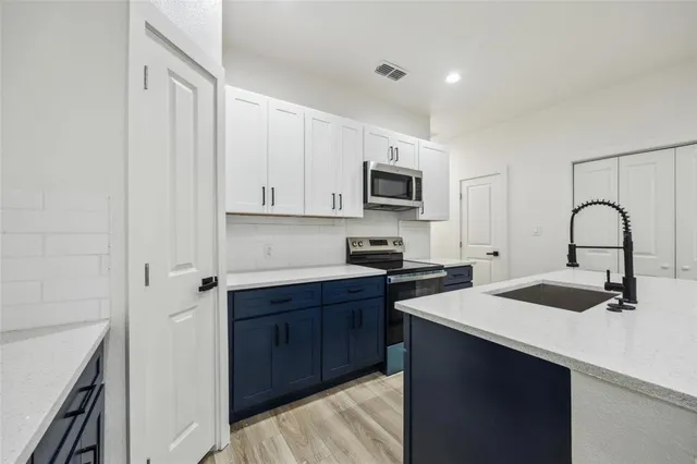 a kitchen with a sink stove and cabinets
