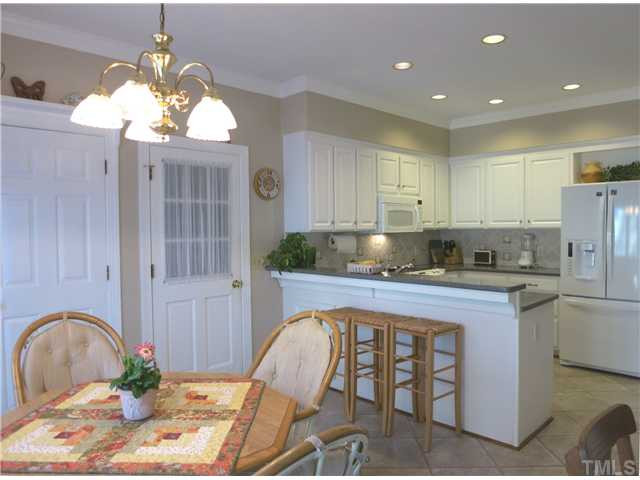 2613 Bembridge Drive Raleigh, NC 27613 - Photo 10 of 25 Over the eat-at peninsula is the sunny Bfast area w/desk, convenient Laundry closet & doors to the Screened Porch & Garage. Kitchen