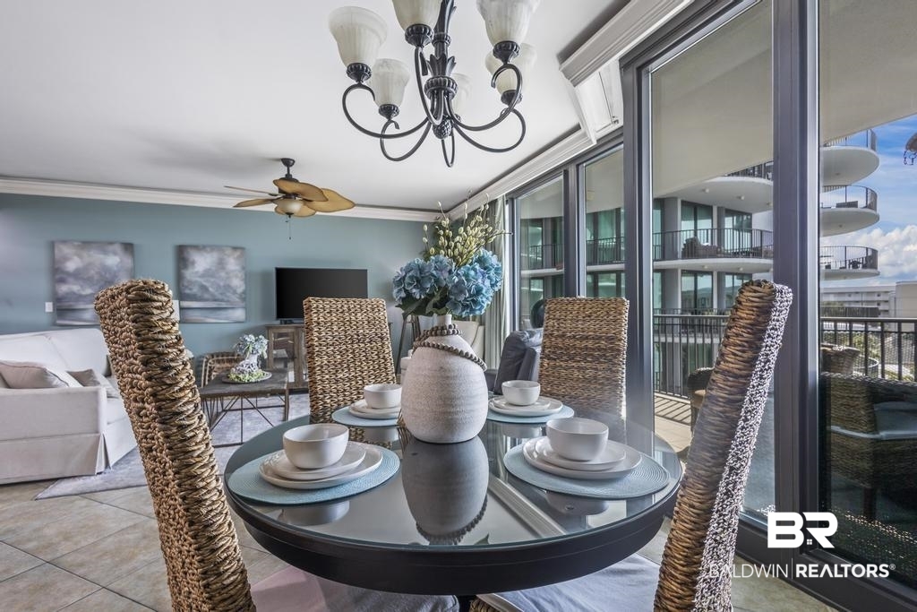 27582 Canal Road, Unit 2408 Orange Beach, AL 36561 - Photo 11 of 47 Dining room featuring crown molding, ceiling fan with notable chandelier, and light tile patterned floors