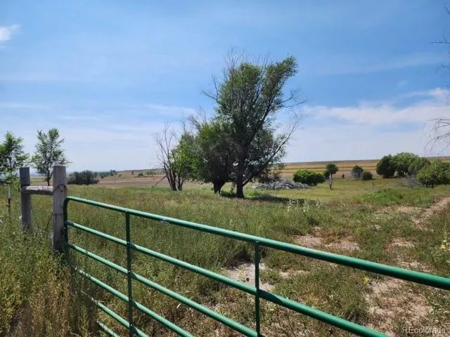 a view of a green field with sitting area