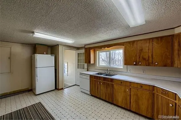 a kitchen with a sink a refrigerator and window