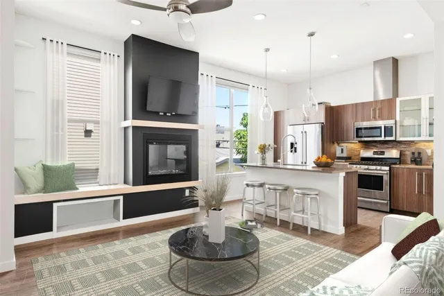 a kitchen with stainless steel appliances granite countertop a stove top oven a sink dishwasher a dining table and chairs with wooden floor