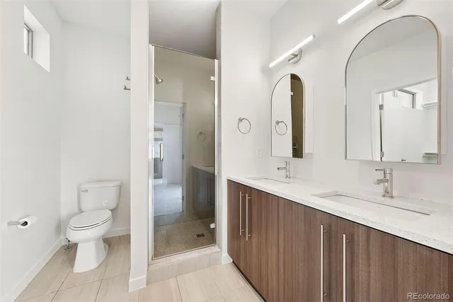 a bathroom with a double vanity sink toilet and shower