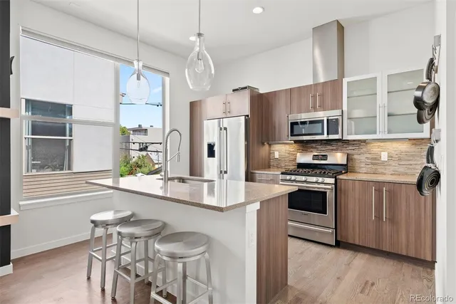 a kitchen with stainless steel appliances a stove a sink island and a refrigerator