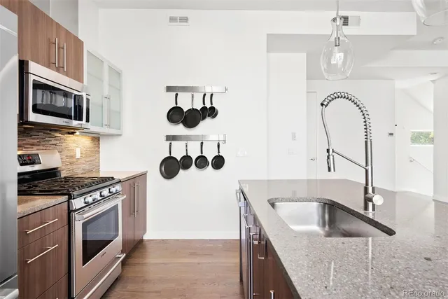 a kitchen with stainless steel appliances granite countertop a sink stove and refrigerator
