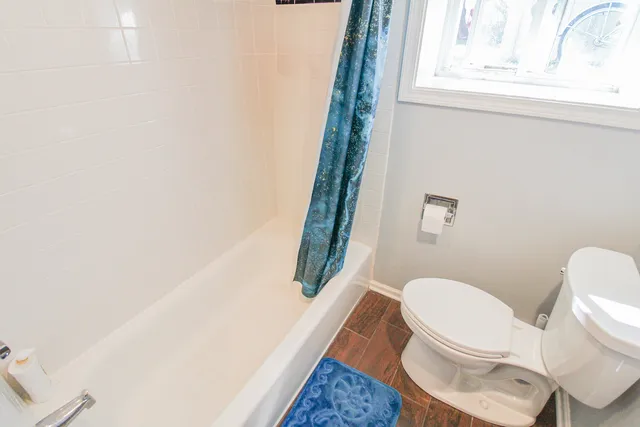 a white toilet sitting next to a window