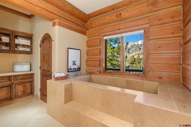 a bathroom with a tub a sink and a large window