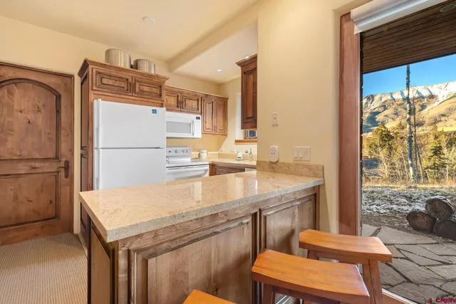 a kitchen with a refrigerator a stove a sink and a dining table