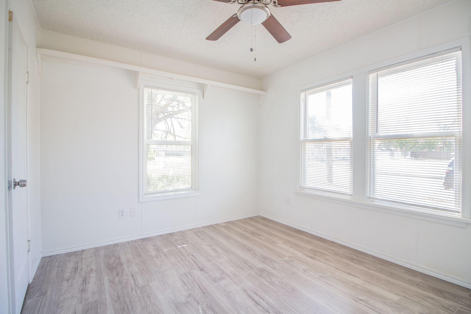 1918 20th Street Lubbock, TX 79411 - Photo 5 of 13 a view of an empty room with a window and wooden floor