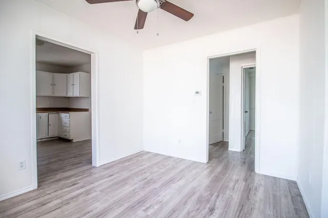 a view of empty room with wooden floor