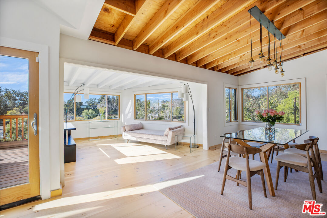 a dining room with wooden floor and outdoor seating