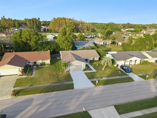 an aerial view of residential houses with outdoor space and trees