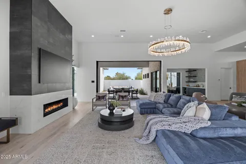 a living room with furniture flat screen tv and a large window