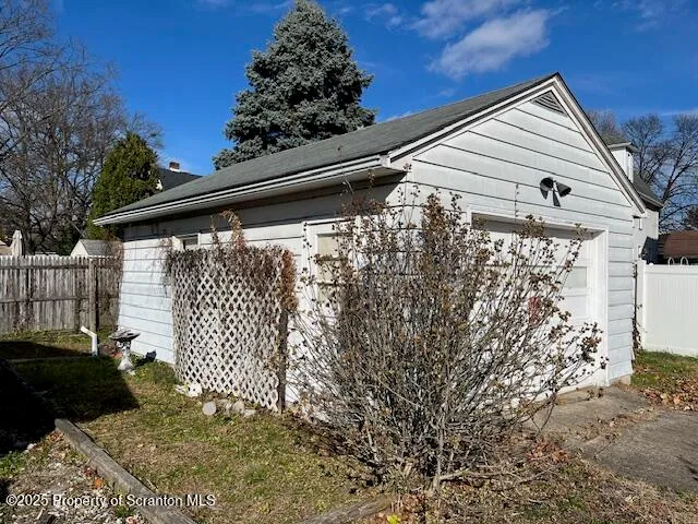 a side view of a house with a large tree