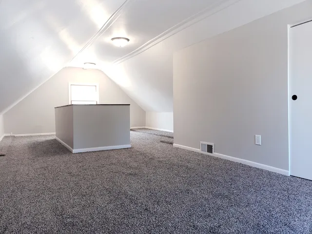 an empty room with windows and stairs