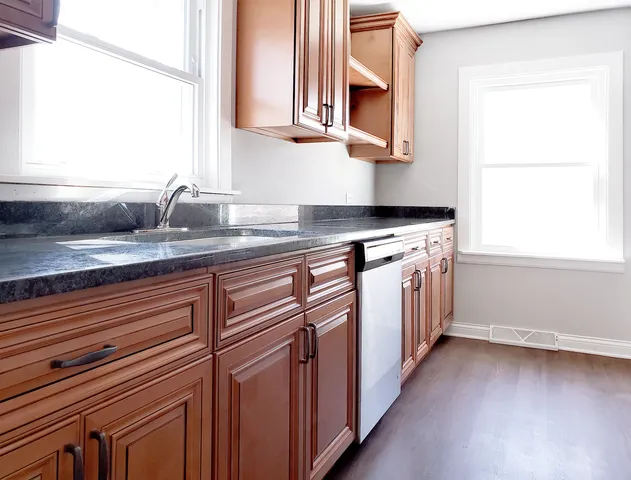 a kitchen with stainless steel appliances granite countertop a sink and a stove