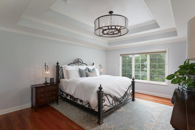 1731 Elyse Lane Naperville, IL 60565 - Photo 17 of 34 a spacious bedroom with a bed and a chandelier
