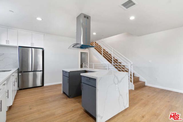a kitchen with refrigerator and white cabinets