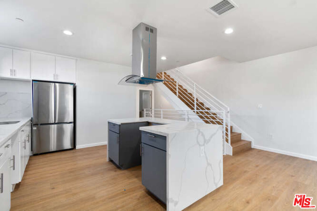 2636 Virginia Road Los Angeles, CA 90016 - Photo 23 of 31 a kitchen with refrigerator and white cabinets