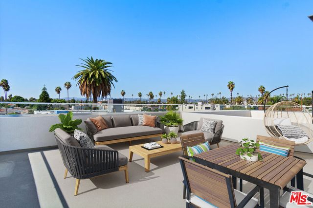 a roof deck with couches and wooden floor