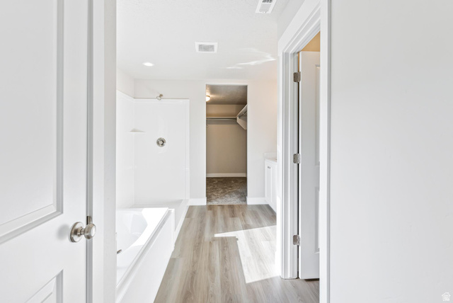 387 Slant Road, Unit 30 Spanish Fork, UT 84660 - Photo 17 of 25 Contemporary bathroom featuring a built-in tub with shower, wood-finish flooring, recessed lighting, and bright white walls