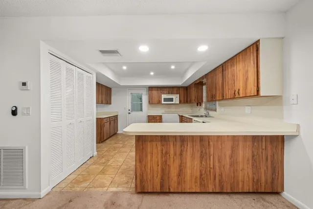 a kitchen with stainless steel appliances granite countertop wooden cabinets a stove top oven a sink and dishwasher