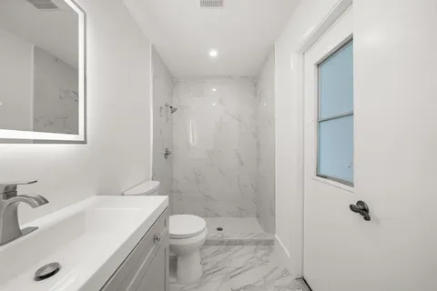 a bathroom with a sink a toilet and shower