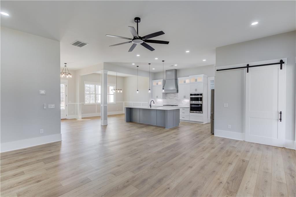 30 River Overlook Way Jefferson, GA 30549 - Photo 19 of 66 a view of an empty room and kitchen with wooden floor