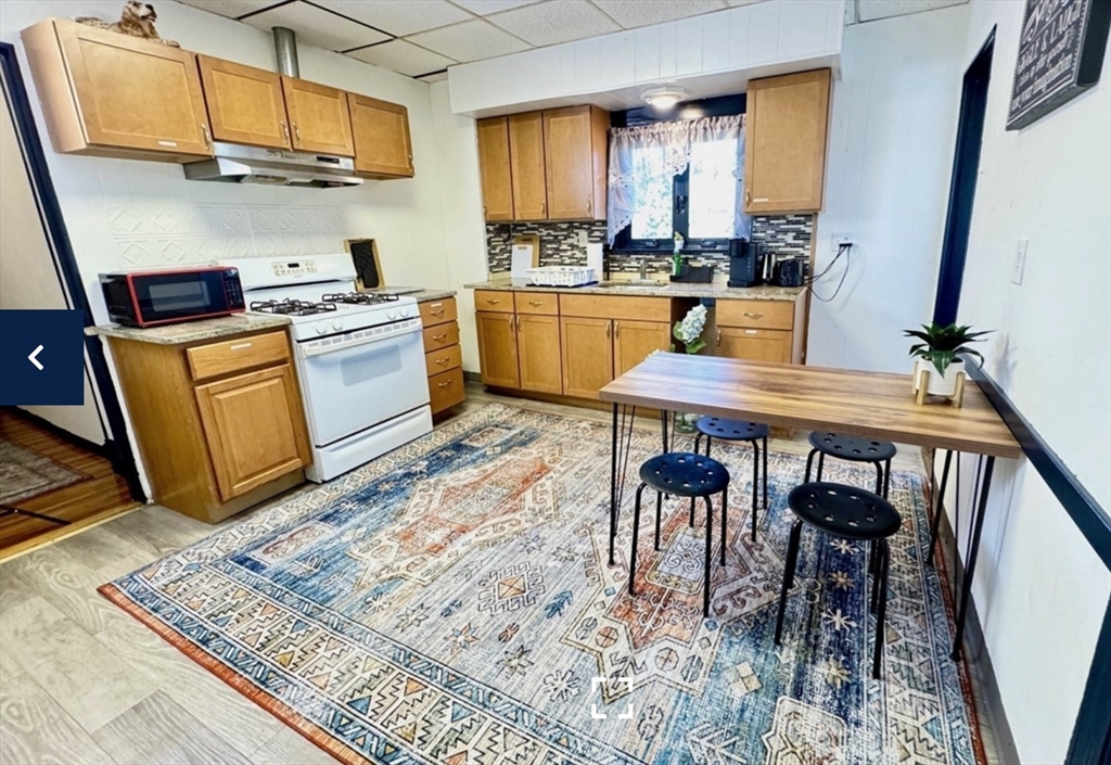 a kitchen with a table chairs sink and cabinets