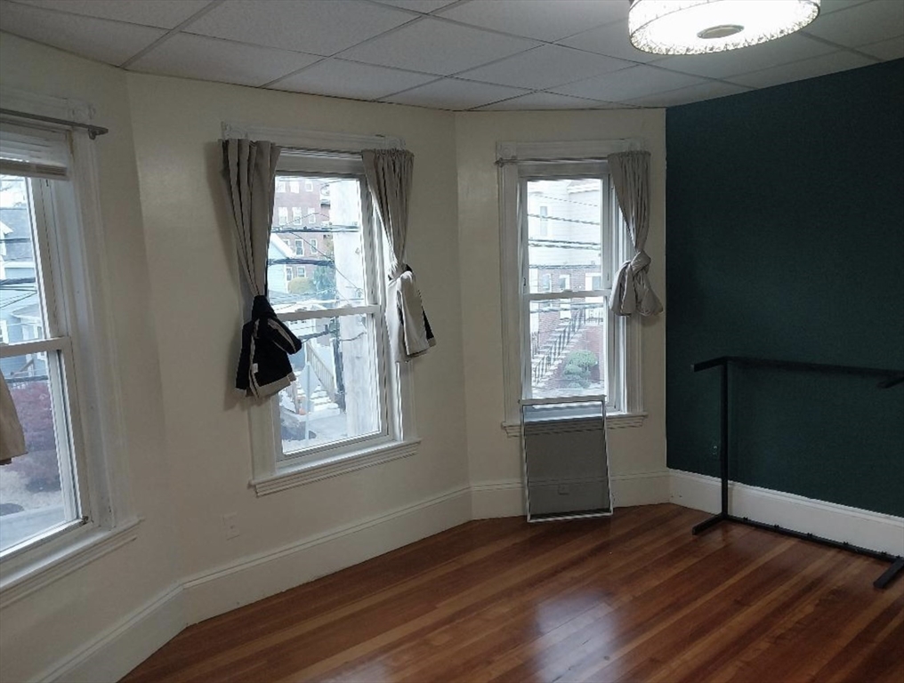 1656 North Shore Road, Unit 1 Revere, MA 02151 - Photo 17 of 18 a view of an empty room with wooden floor and a window