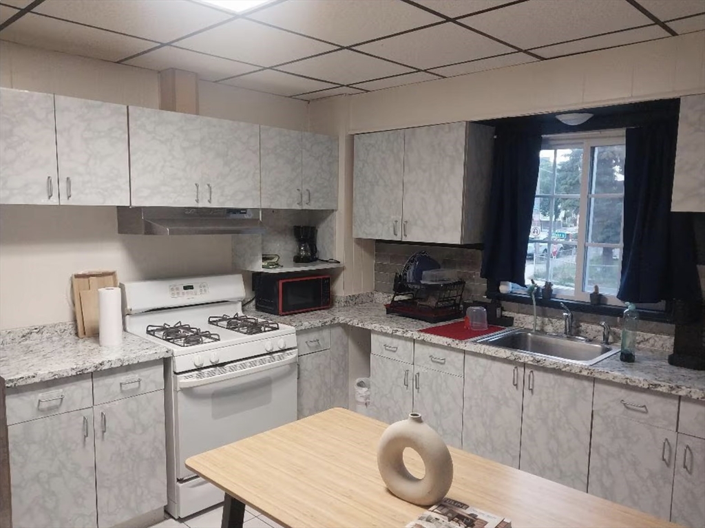 1656 North Shore Road, Unit 1 Revere, MA 02151 - Photo 18 of 18 a kitchen with a sink stove top oven and cabinets