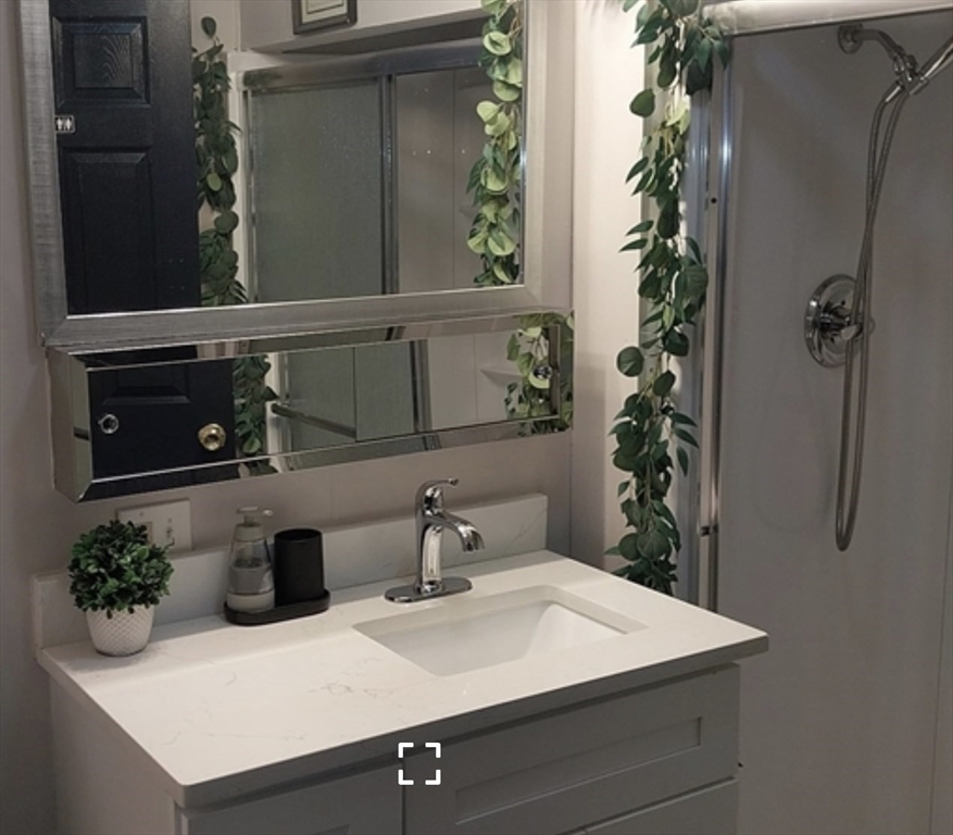 1656 North Shore Road, Unit 1 Revere, MA 02151 - Photo 2 of 18 a bathroom with a sink and mirror