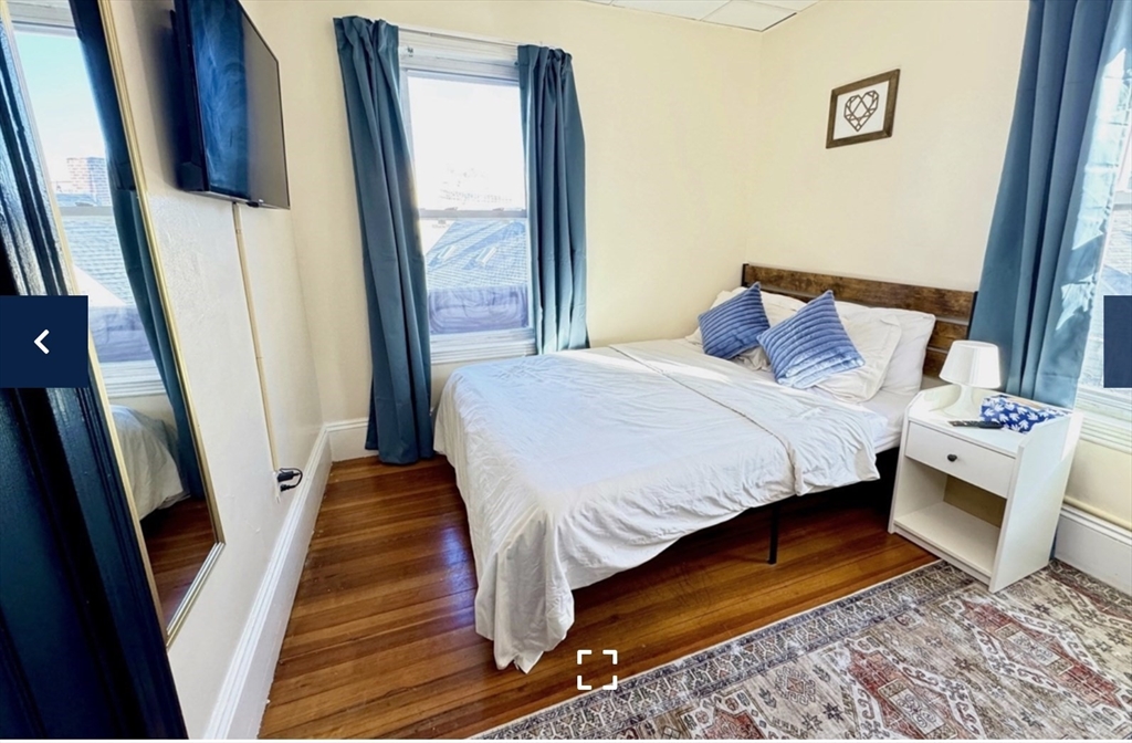 1656 North Shore Road, Unit 1 Revere, MA 02151 - Photo 3 of 18 a bedroom with a bed and a mirror on the dresser
