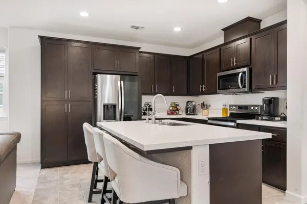 a kitchen with stainless steel appliances granite countertop a sink a stove and refrigerator