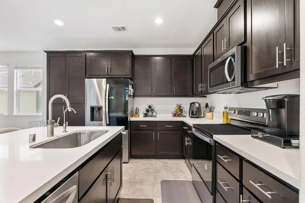 a kitchen with stainless steel appliances granite countertop a sink and stove top oven