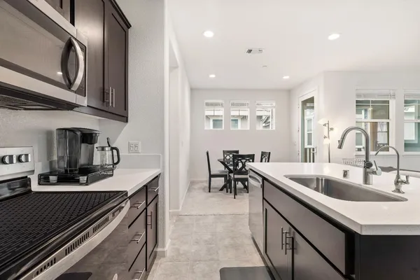 a view of kitchen with stainless steel appliances kitchen island sink living room and living room