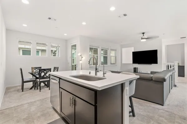 a kitchen with kitchen island a refrigerator and a stove top oven