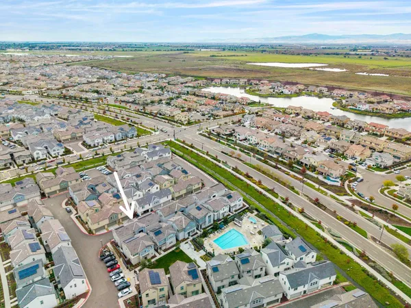 an aerial view of residential houses with outdoor space and ocean view