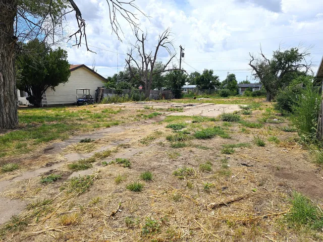 a view of a house with a yard and wooden fence