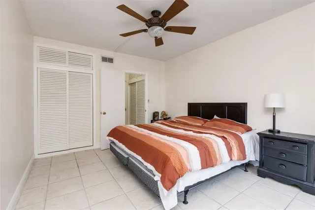 a bedroom with a bed and a ceiling fan