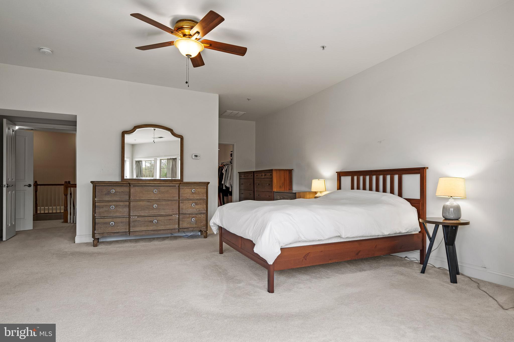 8722 Polished Pebble Way Laurel, MD 20723 - Photo 17 of 58 a spacious bedroom with a bed and a chandelier