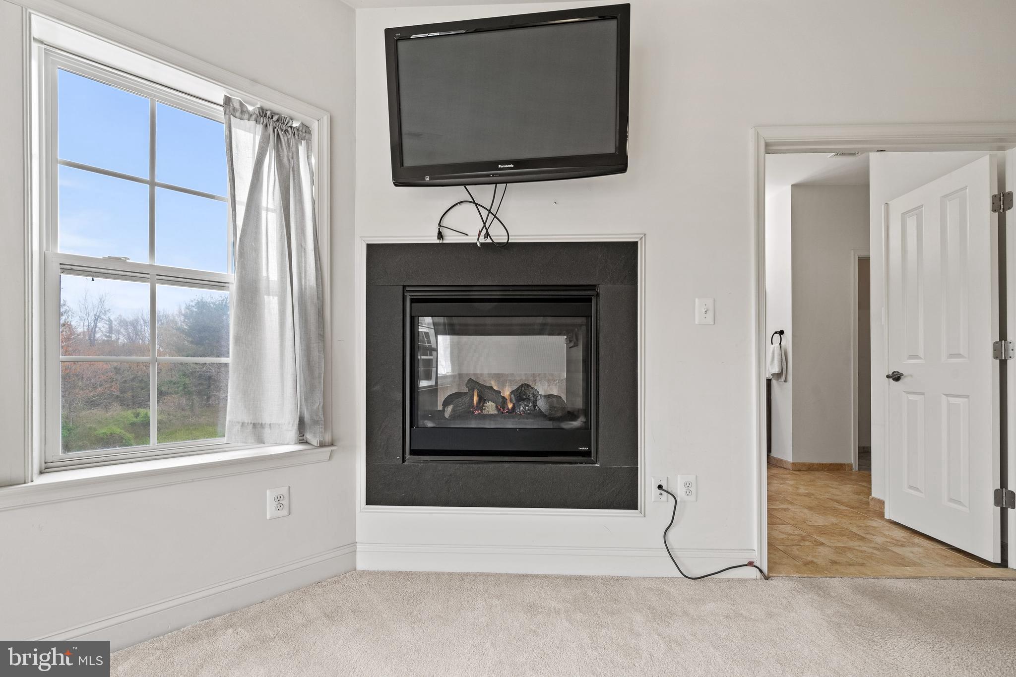 8722 Polished Pebble Way Laurel, MD 20723 - Photo 20 of 58 a living room with a fireplace and a flat screen tv