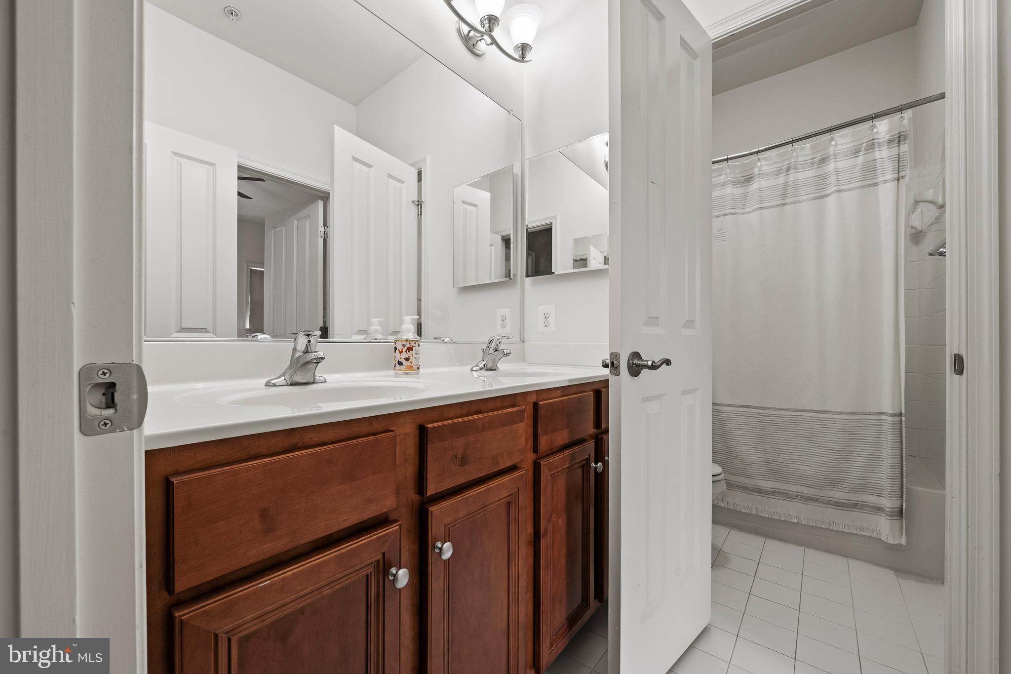 8722 Polished Pebble Way Laurel, MD 20723 - Photo 30 of 58 a bathroom with a double vanity sink mirror and shower