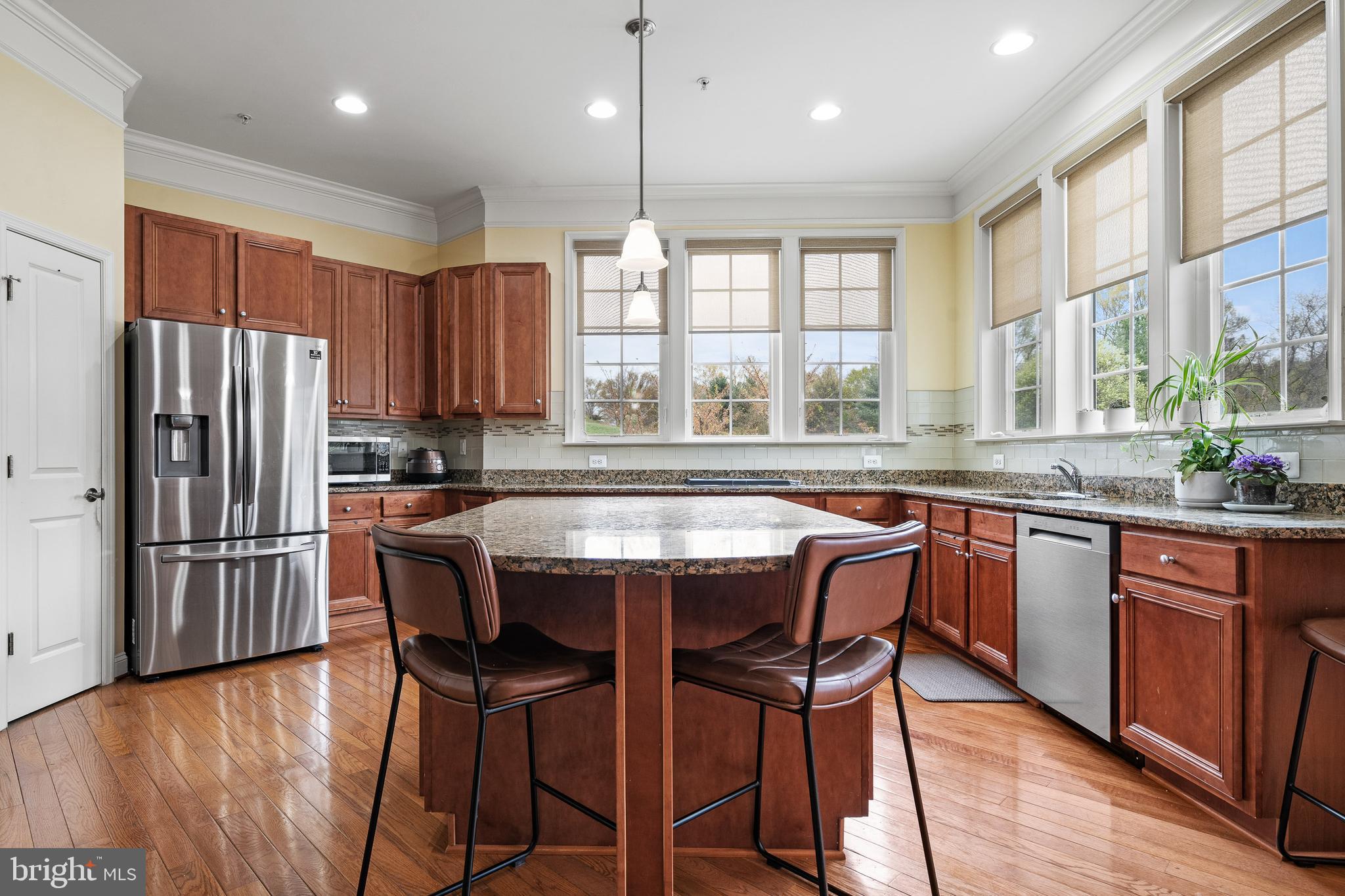 8722 Polished Pebble Way Laurel, MD 20723 - Photo 5 of 58 a kitchen with stainless steel appliances granite countertop a stove a sink a refrigerator and wooden cabinets