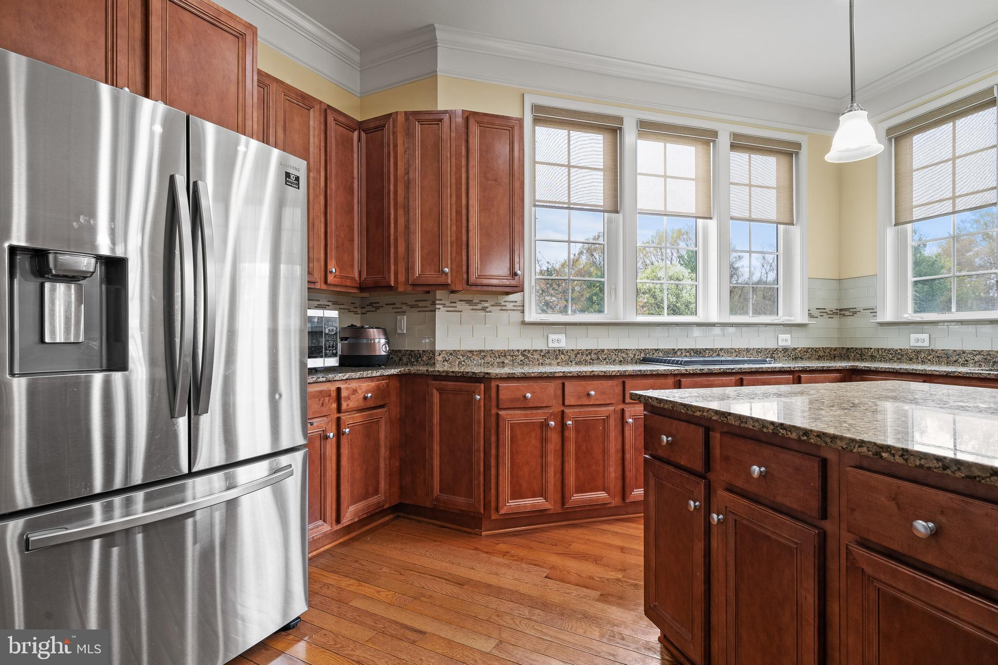 8722 Polished Pebble Way Laurel, MD 20723 - Photo 6 of 58 a kitchen with stainless steel appliances granite countertop a refrigerator and a sink