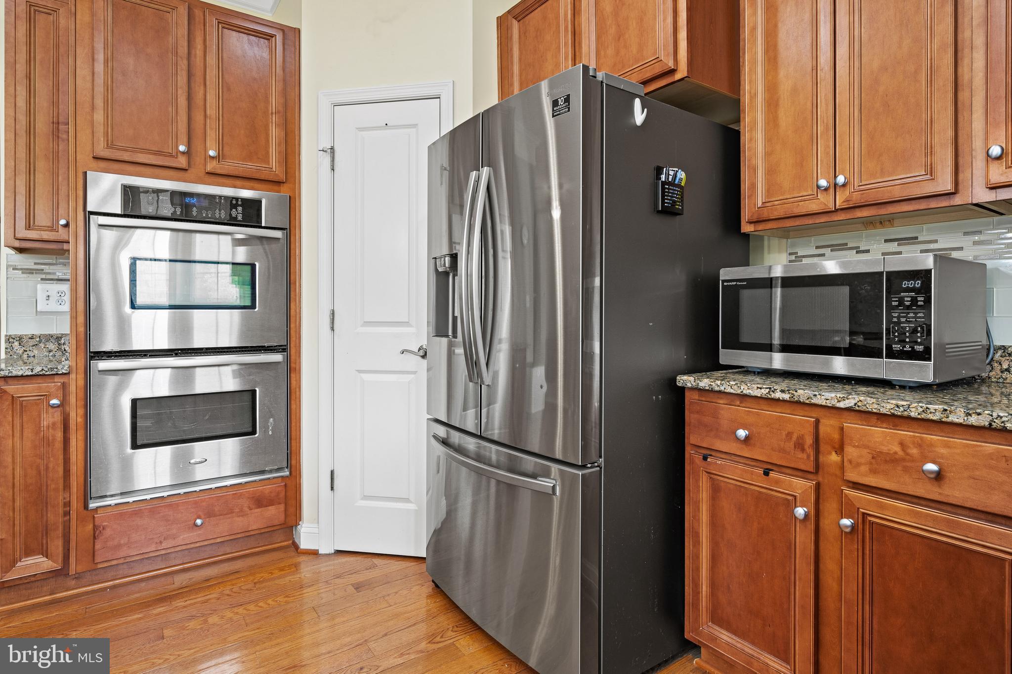 8722 Polished Pebble Way Laurel, MD 20723 - Photo 7 of 58 a kitchen with stainless steel appliances granite countertop a refrigerator and cabinets