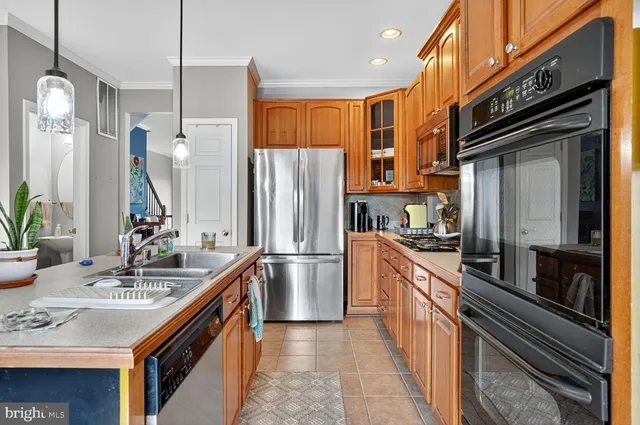a kitchen with stainless steel appliances a sink stove and refrigerator