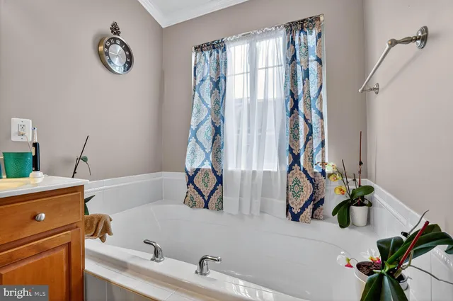 a bathroom with a tub sink and mirror
