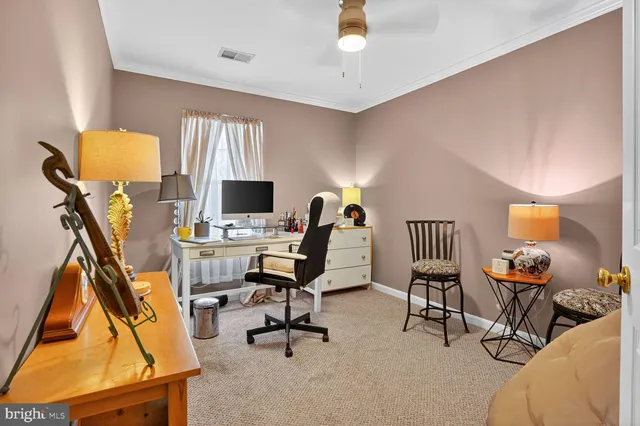 a view of a workspace with furniture and a window